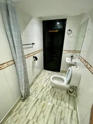 a bathroom with a toilet and a black door at Appartement de lux in Casablanca