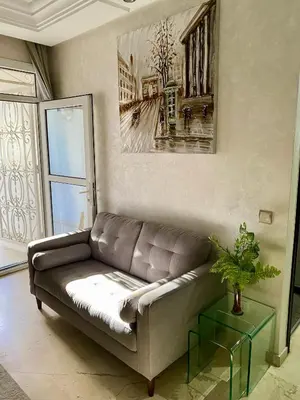a living room with a couch and a painting on the wall at Appartement de lux in Casablanca