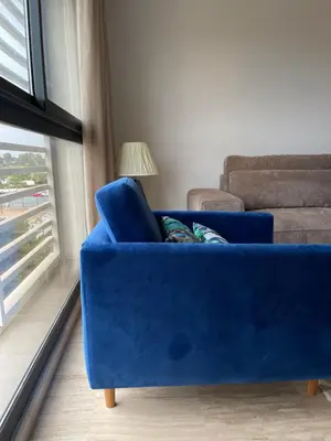 a blue couch in a living room with a window at Luxury Flat in Casa Finance City in Casablanca