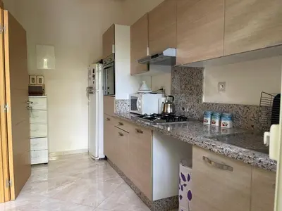 a kitchen with wooden cabinets and a counter top at The garden corner in Bouznika