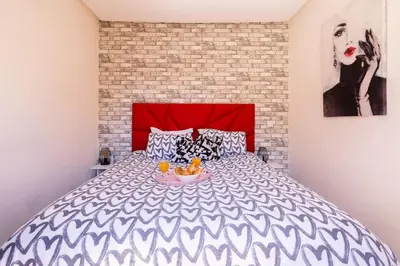 a bedroom with a large bed with a red headboard at Terrasses de Marrakech- Au coeur de Casablanca in Casablanca