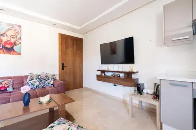 a living room with a couch and a tv at Terrasses de Marrakech- Au coeur de Casablanca in Casablanca