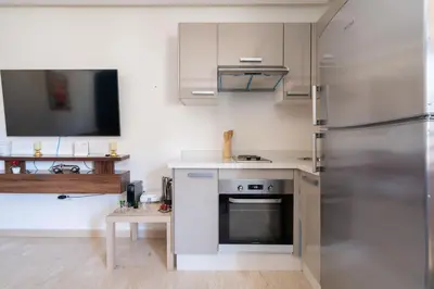 a kitchen with white cabinets and a stainless steel refrigerator at Terrasses de Marrakech- Au coeur de Casablanca in Casablanca