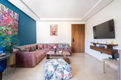a living room with a couch and a flat screen tv at Terrasses de Marrakech- Au coeur de Casablanca in Casablanca