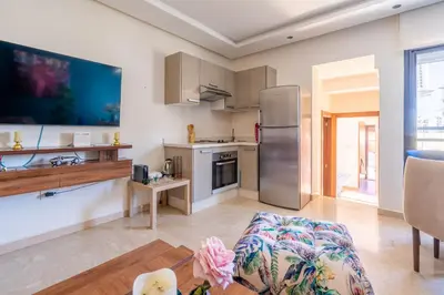 a kitchen and living room with a stainless steel refrigerator at Terrasses de Marrakech- Au coeur de Casablanca in Casablanca