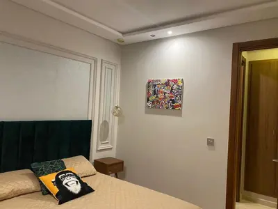 a bedroom with a bed and a painting on the wall at Les Jardins de l'Oasis - 2 rooms in Casablanca