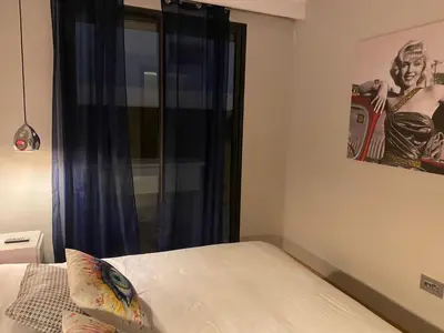 a bedroom with a bed and a window with a picture at Les Jardins de l'Oasis - 2 rooms in Casablanca
