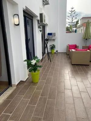 a living room with a couch and flowers on the floor at Les Jardins de l'Oasis - 2 rooms in Casablanca