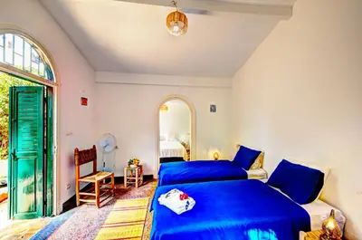 a bedroom with a blue bed and a window at Charmante Maison 2ch et Bungalow 2ch au Coeur de l'Oasis in Casablanca