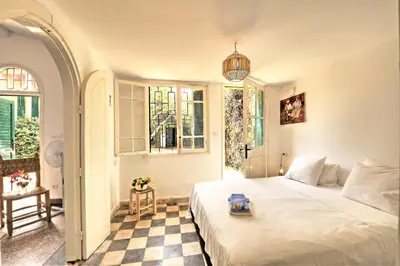 a bedroom with a bed and a checkered floor at Charmante Maison 2ch et Bungalow 2ch au Coeur de l'Oasis in Casablanca