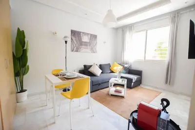 a living room with a couch and a table and yellow chairs at YourPlace - Prestigia - Hay Riad in Rabat