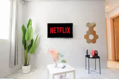 a living room with a netflix sign on a wall at YourPlace - Prestigia - Hay Riad in Rabat