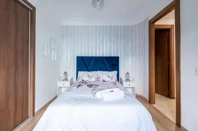 a bedroom with a large white bed with a blue headboard at Jardin de Majorelle location journalière Casablanca in Casablanca