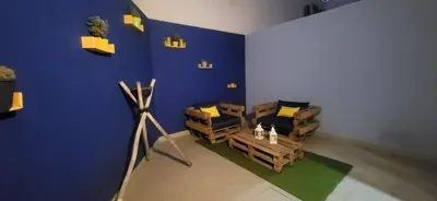 a room with two chairs and a blue wall at Jardin de Majorelle location journalière Casablanca in Casablanca