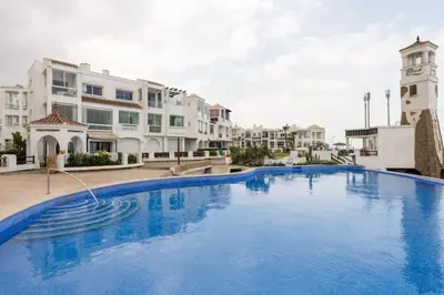 a large blue swimming pool in front of some buildings at appartement de luxe front mer à DAR BOUAAZA in Dar Bouazza