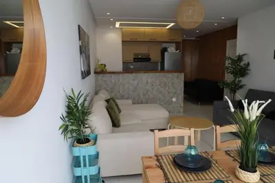 a living room with a white couch and a table at appartement de luxe front mer à DAR BOUAAZA in Dar Bouazza