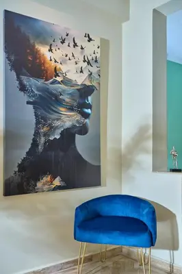 a living room with a blue chair and a painting at YourPlace Rabat Agdal 1 - Cozy Residence in Rabat
