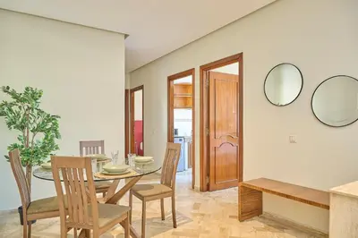 a dining room with a table and chairs and mirrors at YourPlace Rabat Agdal 1 - Cozy Residence in Rabat