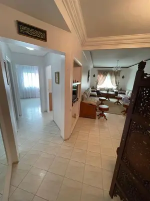 a large living room with a couch and a table at Appartement standing spacieux Casablanca in Casablanca