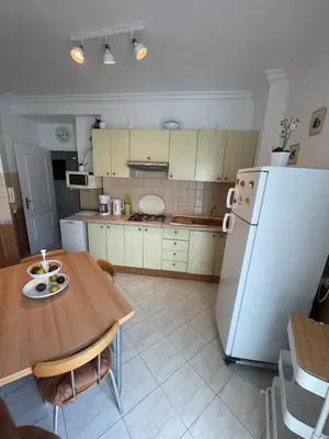 a kitchen with a table and a white refrigerator at Appartement standing spacieux Casablanca in Casablanca
