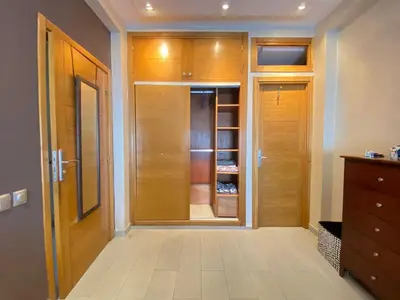 a walk in closet with wooden cabinets and a door at Bright and Comfortable Stay by Stade Mohammed V in Casablanca