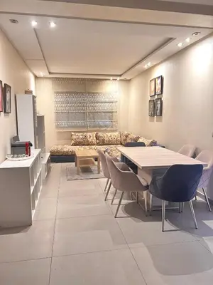 a room with a couch and a table and chairs at Bright and Comfortable Stay by Stade Mohammed V in Casablanca