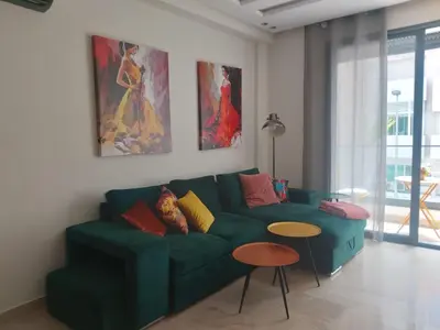 a living room with a green couch and two tables at Havre de paix au cœur de Casa in Casablanca