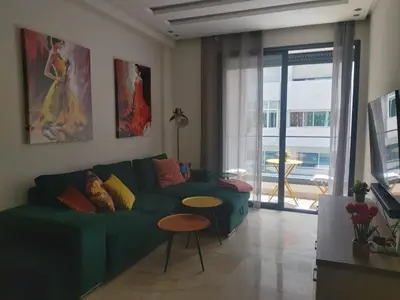 a living room with a green couch and a table at Havre de paix au cœur de Casa in Casablanca