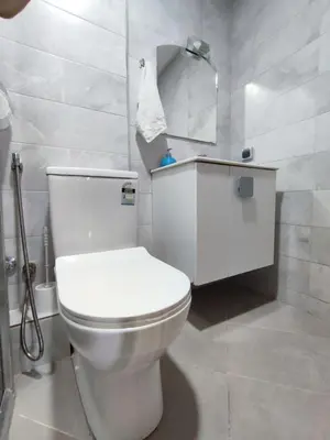 a bathroom with a white toilet and a mirror at Cozy Apartment in Rabat
