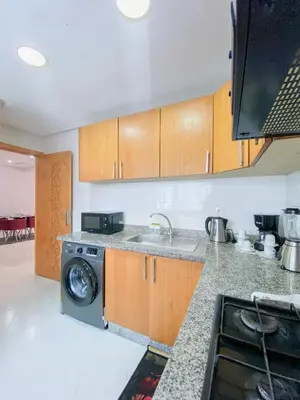a kitchen with a sink and a washing machine at Cozy Apartment in Rabat