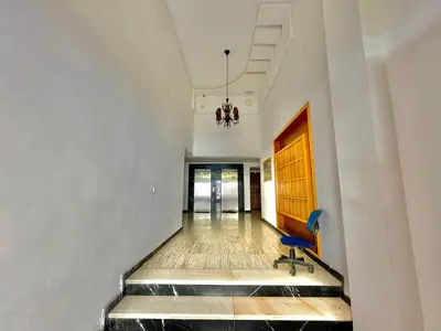a hallway with a blue chair in a building at Cozy Apartment in Rabat