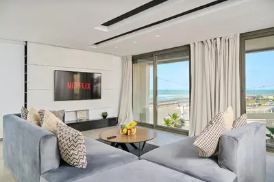 a living room with a couch and a table at TheCasaEdition - Bel Azur - Sea View & Hassan II Mosqué Residency in Casablanca