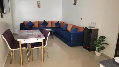 a living room with a blue couch and a table at Bel Appartement spacieux 3 pièces avec double salon Paisible & Proche de la Gare d'Agdal in Rabat