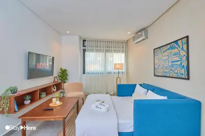 a living room with a blue couch and a table at Stayhere Casablanca - Gauthier 2 - Contemporary Residence in Casablanca