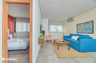 a living room with a blue couch and a bed at Stayhere Casablanca - Gauthier 2 - Contemporary Residence in Casablanca