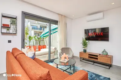 a living room with a orange couch and a table at Stayhere Casablanca - Gauthier 2 - Contemporary Residence in Casablanca