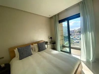 a bedroom with a bed and a large window at Luxueux Appartement avec Vue Panoramique, Proche de la Gare WELCOME STAY in Casablanca