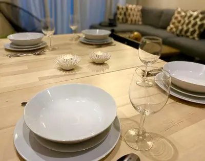 a table with plates and wine glasses on it at Luxueux Appartement avec Vue Panoramique, Proche de la Gare WELCOME STAY in Casablanca