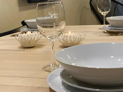 a table with a glass of wine and plates on it at Luxueux Appartement avec Vue Panoramique, Proche de la Gare WELCOME STAY in Casablanca