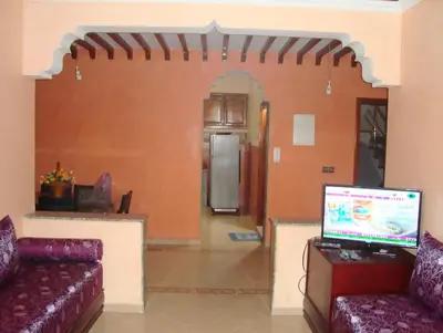 a living room with two couches and a kitchen at Yasmine Appartements in Temara