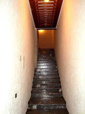 a stairway leading down to a room with orange walls at Yasmine Appartements in Temara
