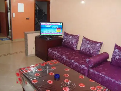 a living room with a purple couch and a table at Yasmine Appartements in Temara