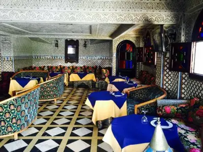 a restaurant with tables and chairs with blue and yellow at HOTEL AL MAMOUN in Casablanca