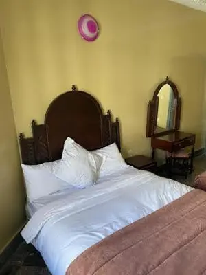 a bedroom with a white bed with a pink clock on the wall at HOTEL AL MAMOUN in Casablanca