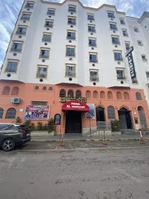 a large building with a car parked in front of it at HOTEL AL MAMOUN in Casablanca