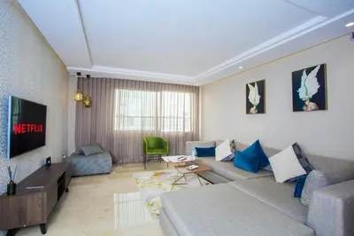a living room with a couch and a tv at Top flat at central Massira Maarif in Casablanca