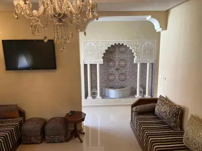 a living room with two couches and a chandelier at Apparemment à mohammadia in Mohammedia