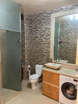 a bathroom with a toilet and a sink and a washing machine at Apparemment à mohammadia in Mohammedia