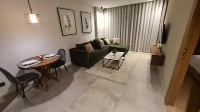 a living room with a green couch and a table at Superbe studio avec une belle terrasse à Gauthier in Casablanca