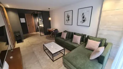 a living room with a green couch and a table at Superbe studio avec une belle terrasse à Gauthier in Casablanca